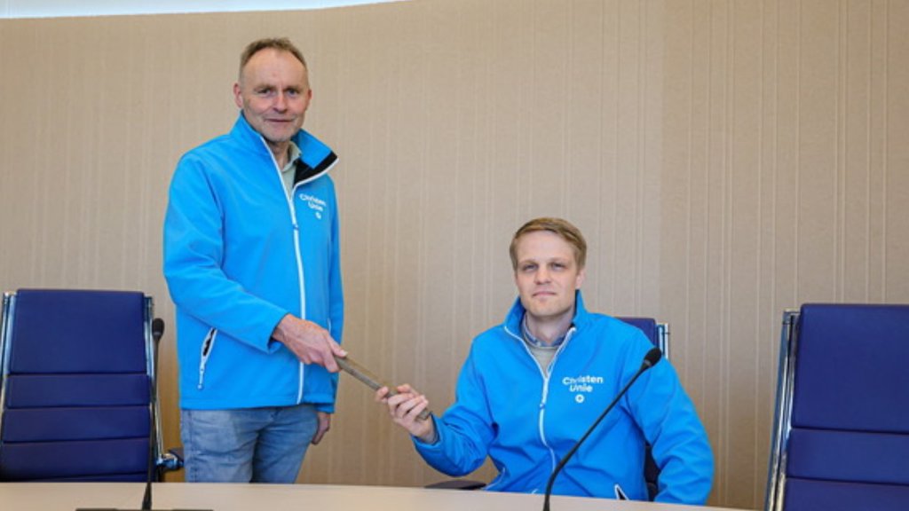 Dick van Gelder (staand) draagt het stokje over aan Thomas Hoekstra