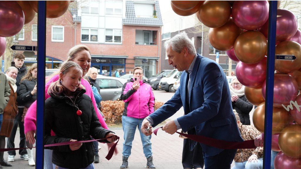wethouder Jan Uitslag knipt het lint door bij de opening van Het Bakhok in Nieuwleusen.
