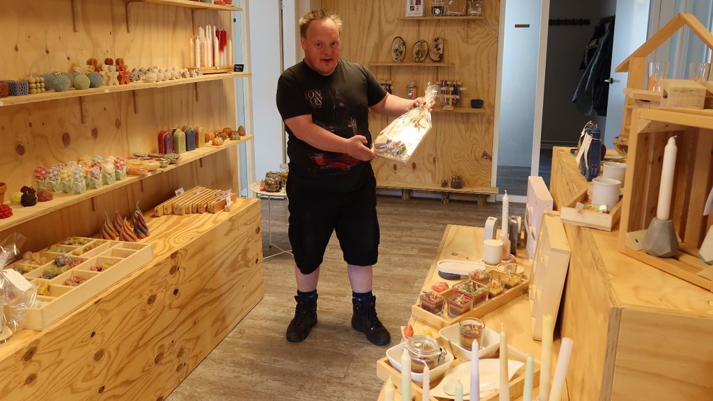 Een van de deelnemers is bezig met het inrichten van de winkel.