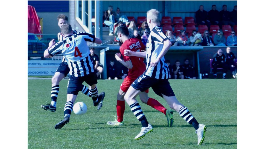 Alex Budding (rood) in de mangel bij verdedigers SVV’04.