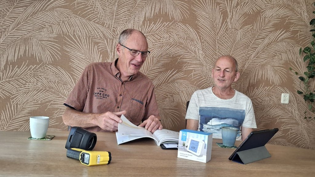 Coördinator Jan Nijman (links) geeft informatie aan een inwoner. 