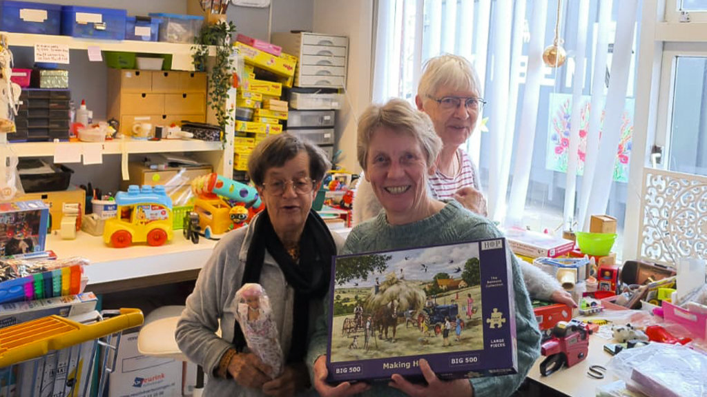 Vlnr. vrijwilligers Hennie, Ria en Nel bereiden de speelgoedmarkt voor bij Noggus&Noggus Dalfsen.
