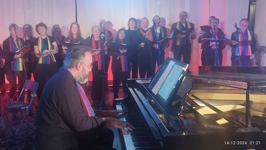 Het Regenboogkoor One Voice met pianist-dirigent Harrie Herfst. (Foto: aangeleverd)
