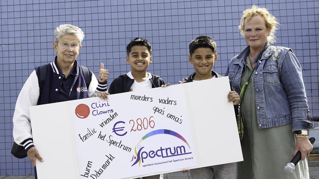 In bijzijn van AnneMarie Sierag van Het Spectrum (rechts) overhandigden kinderburgemeesters Hakiran en Ekam de cheque aan Ellen van de CliniClowns. (Foto: Erik van Soest)