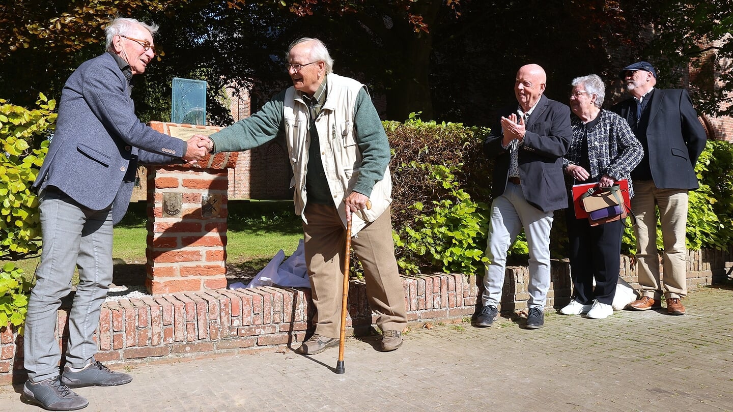 Piet Cup (links) schudt de hand van Jan van Dijk. Samen onthulden ze het nieuwe monument. 