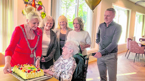 De honderdjarige Corry de Jagher-de Bont met burgemeester de Hoon-Veelenturf en vier van haar kinderen.
