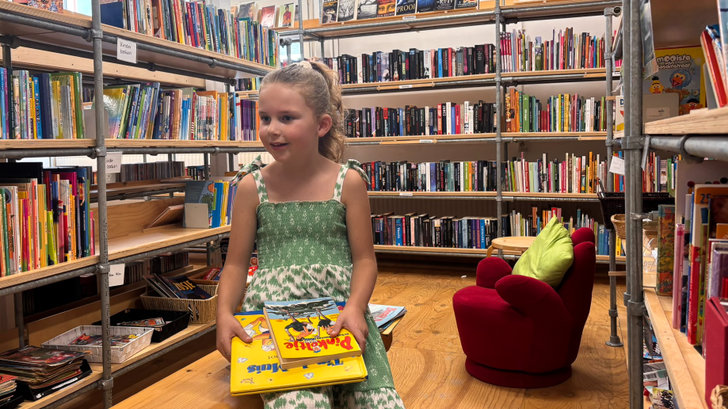 Janah (7 jaar) met haar geruilde boeken.