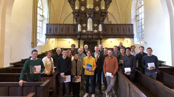Burgemeester Hans Broekhuizen tussen de deelnemers aan het orgelconcours. Foto: Roelof Kooiker.