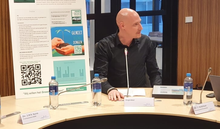 Een van de insprekers bood de petitie tegen inbreiding aan namens ruim 800 bewoners. (Foto: Almere DEZE WEEK)