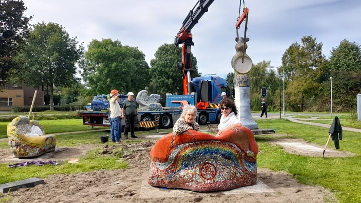 Kunstenaar Emeke Buitelaar (links) en kunstambassadeur Michelle Friedländer proberen even uit hoe het bankje zit op de nieuwe locatie aan de Meistraat. (Foto: Almere DEZE WEEK)