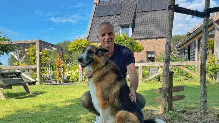 Makelaar Alex van Keulen en zijn hond bij zijn huis dat te koop staat (Foto: Almere DEZE WEEK)