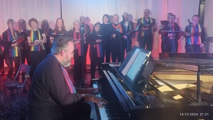 Het Regenboogkoor One Voice met pianist-dirigent Harrie Herfst. (Foto: aangeleverd)