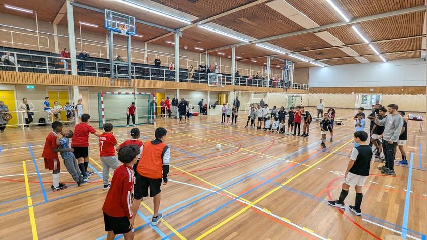 Jongeren vermaken zich tijdens zaalvoetbaltoernooi