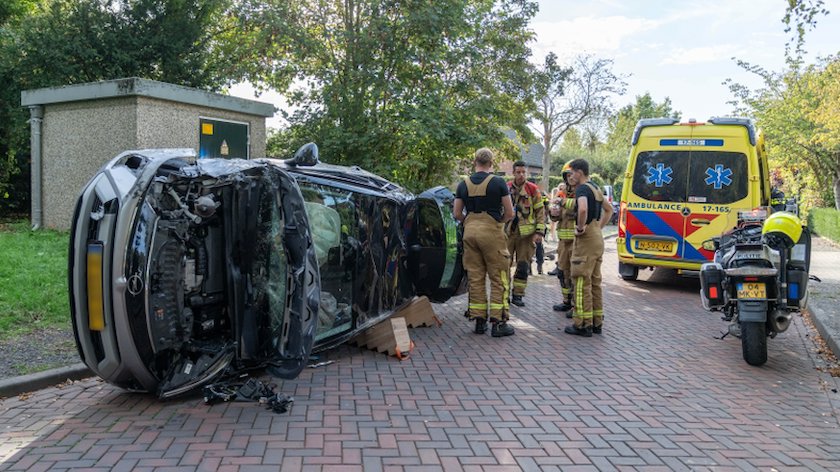 Auto ramt geparkeerde auto en slaat over de kop, grote ravage