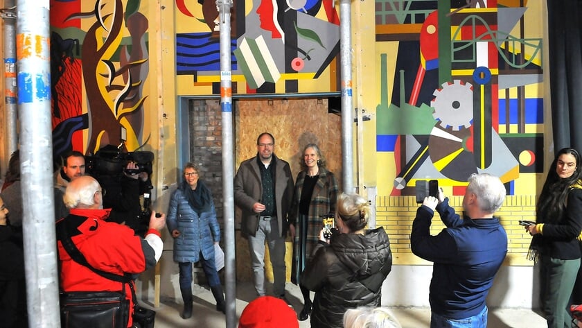 Eltjo Dijkhuis heeft de muurschildering onthuld. Het kunstwerk wordt bewonderd.