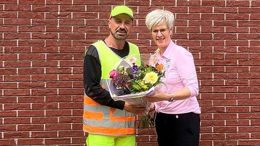 Gemeentebode Christina van Dijken overhandigt het boeket aan Agim.
