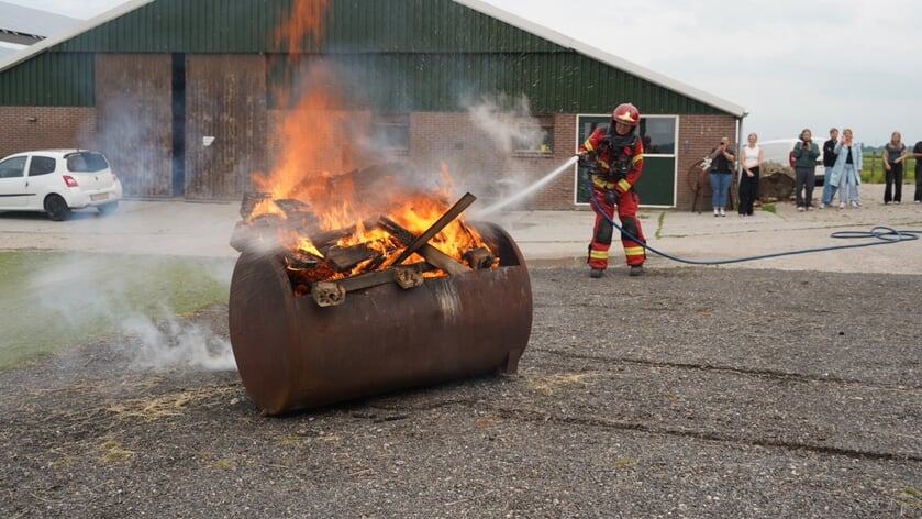 Onder toeziend oog van zijn collega's, familie en vrienden blust Jaap van Dijken zijn laatste brandje. Foto: NoorderNieuws. 