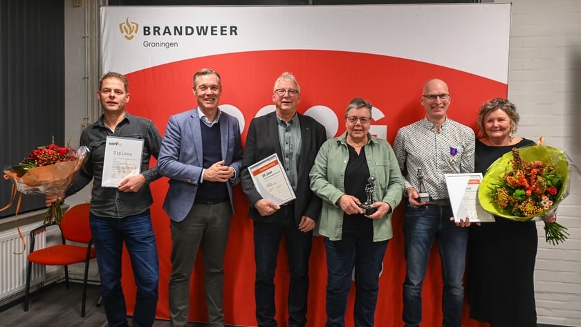 Burgemeester Hans Broekhuizen van Het Hogeland met de gehuldigde Bedumer brandweerlieden en hun partners.