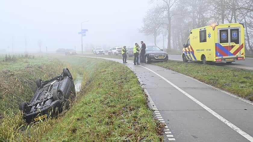 De auto eindigde op de kop in een diepe sloot, waar gelukkig weinig water in stond (foto NoorderNieuws).