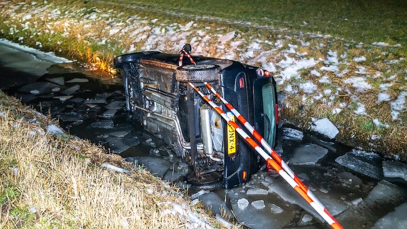 Een van de auto's belandde op de zijkant in een sloot met ijs (foto NoorderNieuws).