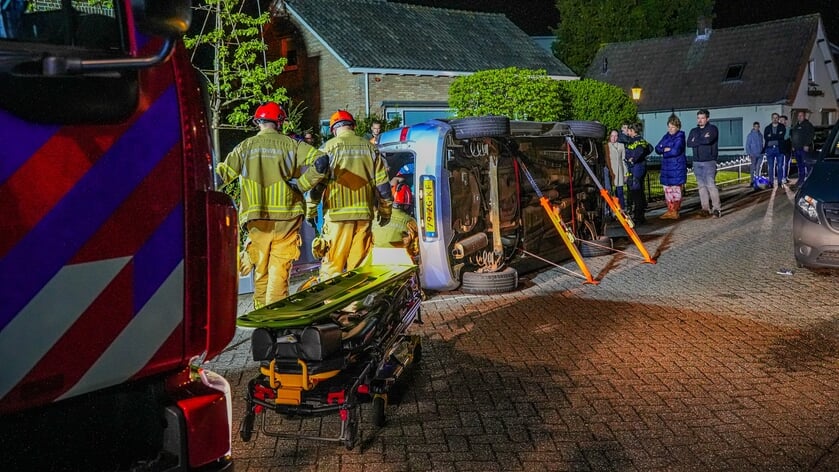 Auto belandt op zijkant na botsing met geparkeerde bus in Veen