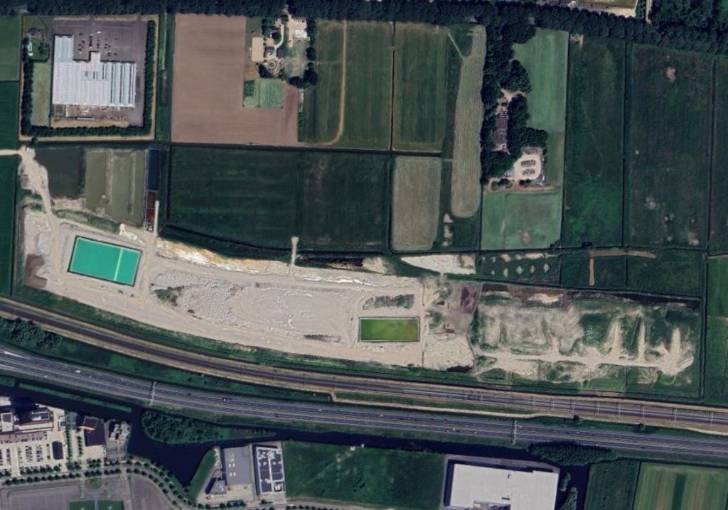 Het terrein met links het bassin met verontreinigd water.