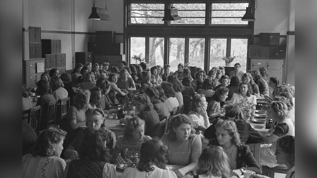 Oudere meisjes gezamenlijk aan het eten in de jeugdinternaat voor NSB-kinderen.