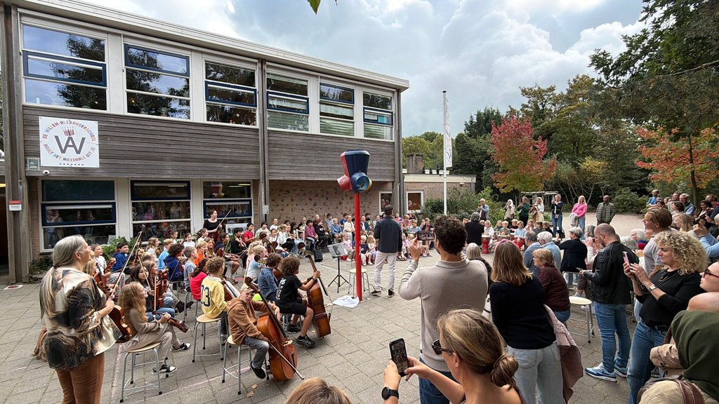 Ouders keken vrolijk naar het concert van hun kinderen.