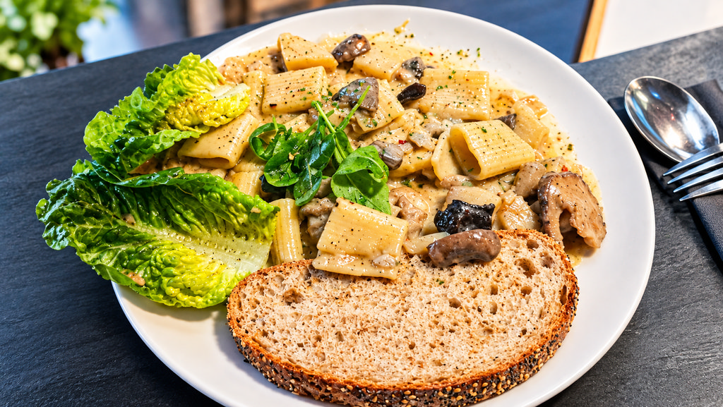 Verse paste met champignonragout, sla en een sneedje brood.