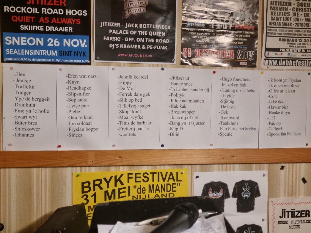 Opsomming van songtitels op de muur van het oefenhok.