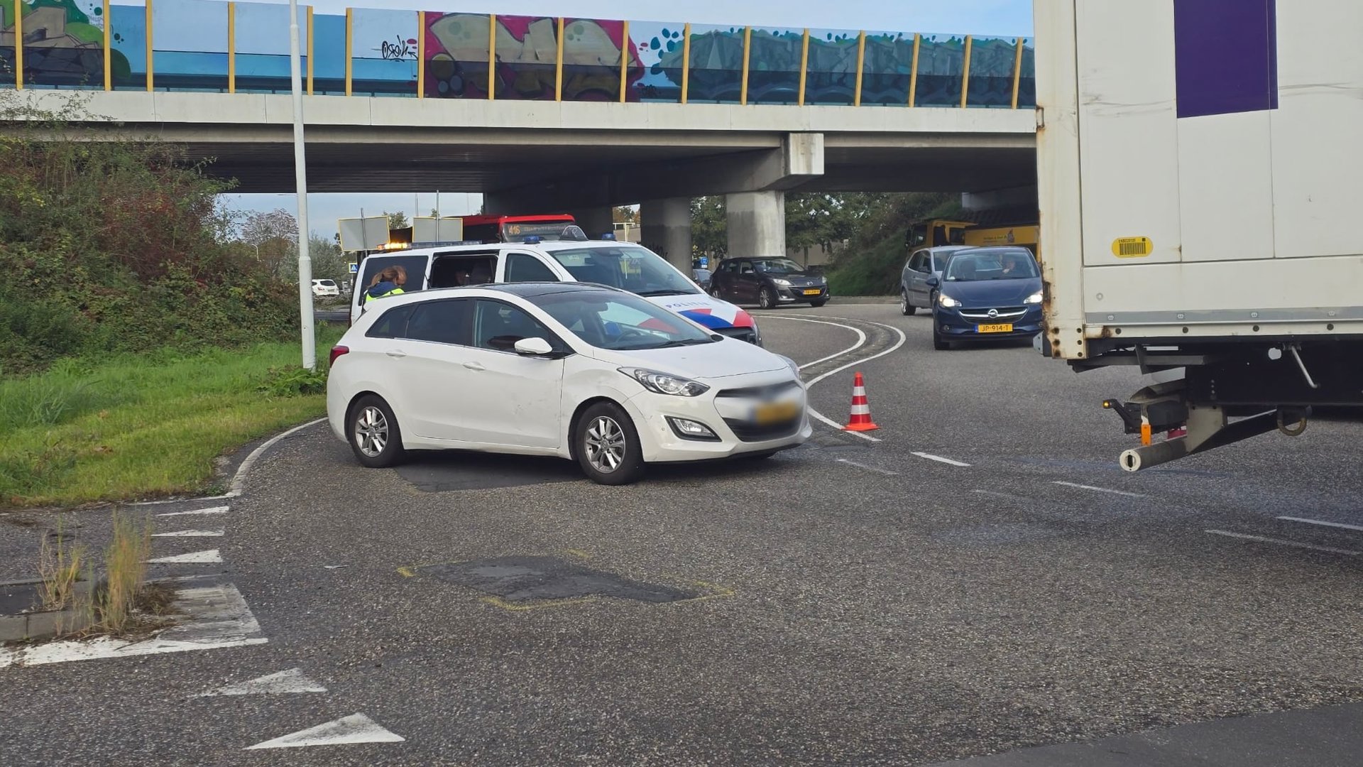 Auto klem onder trailer van Roemeense vrachtwagen op Burgemeester Keijzerweg