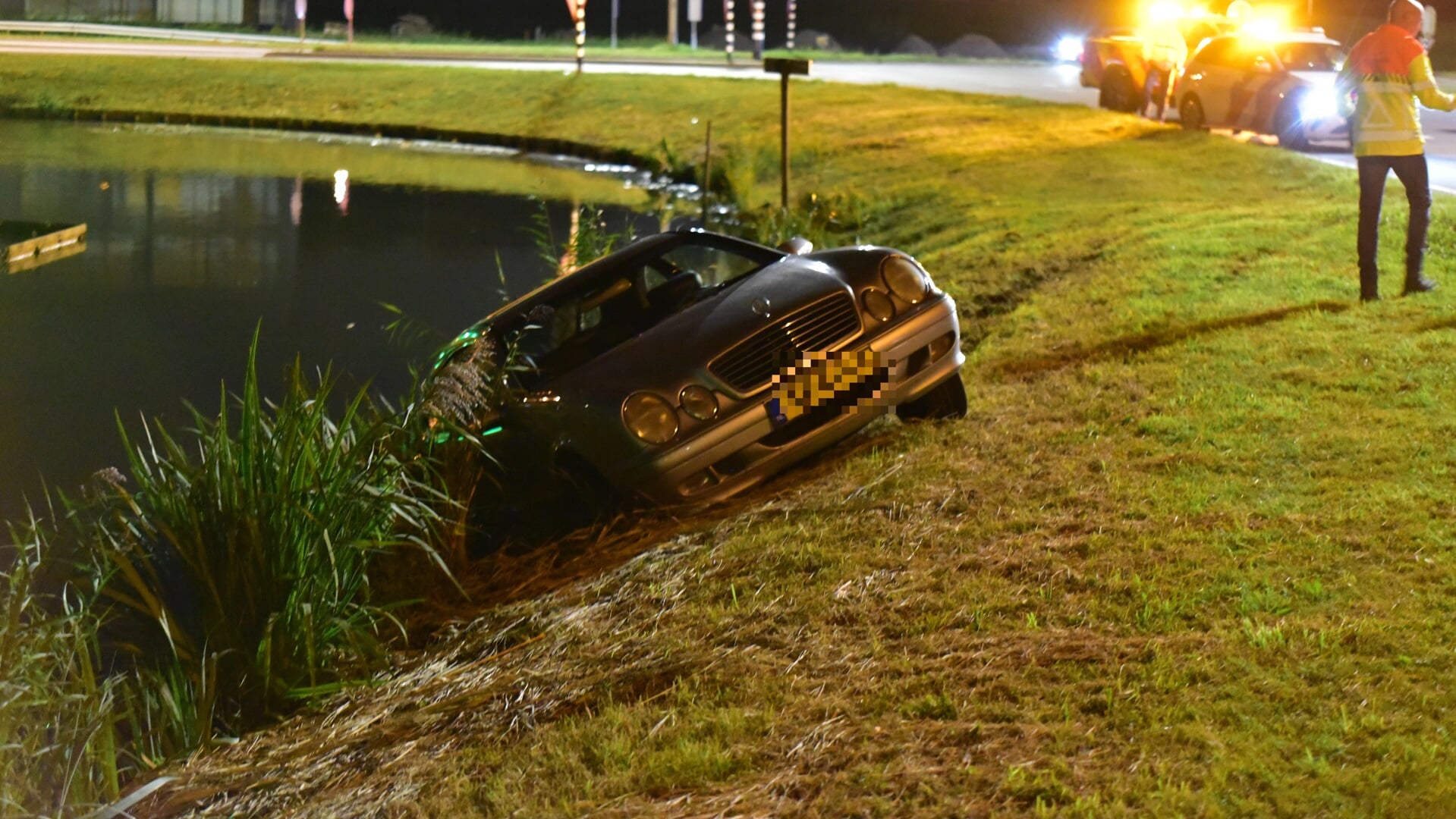 Voertuig vliegt uit de bocht en belandt half in het water in Maasdijk: bestuurder spoorloos