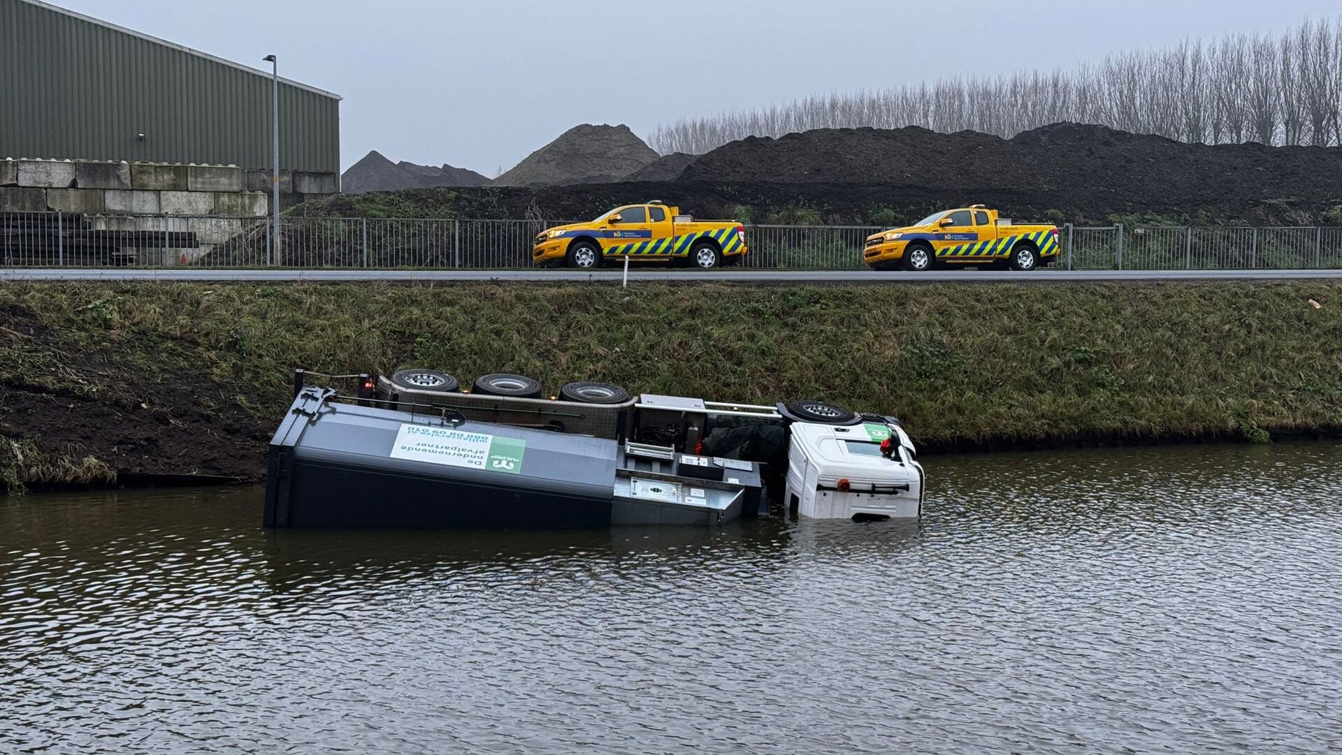 Vrachtwagen in water langs Hoofdweg in Lijnden