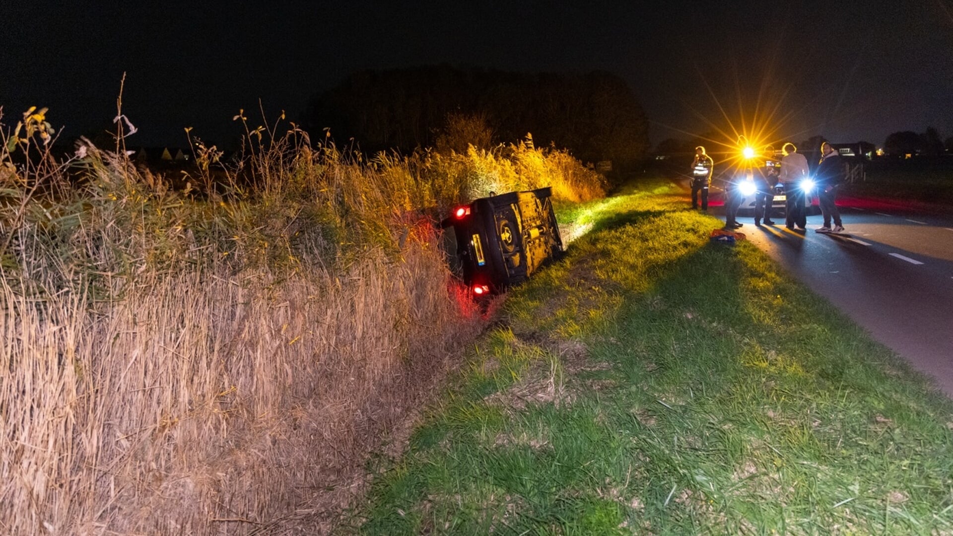 Auto belandt op zijkant in greppel aan Wijzend in Lutjebroek