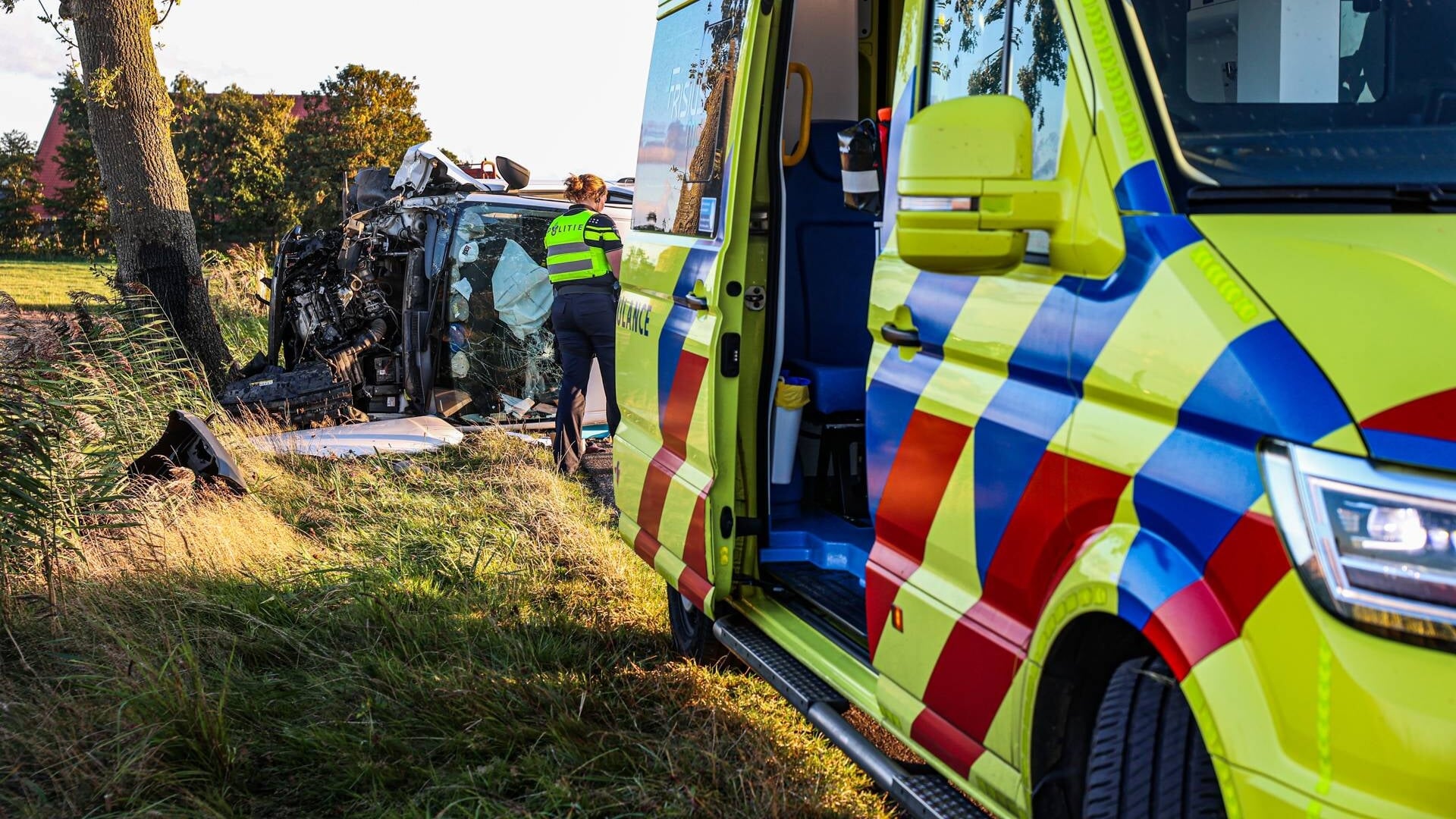 Bestelbus botst tegen boom en komt op zijkant terecht