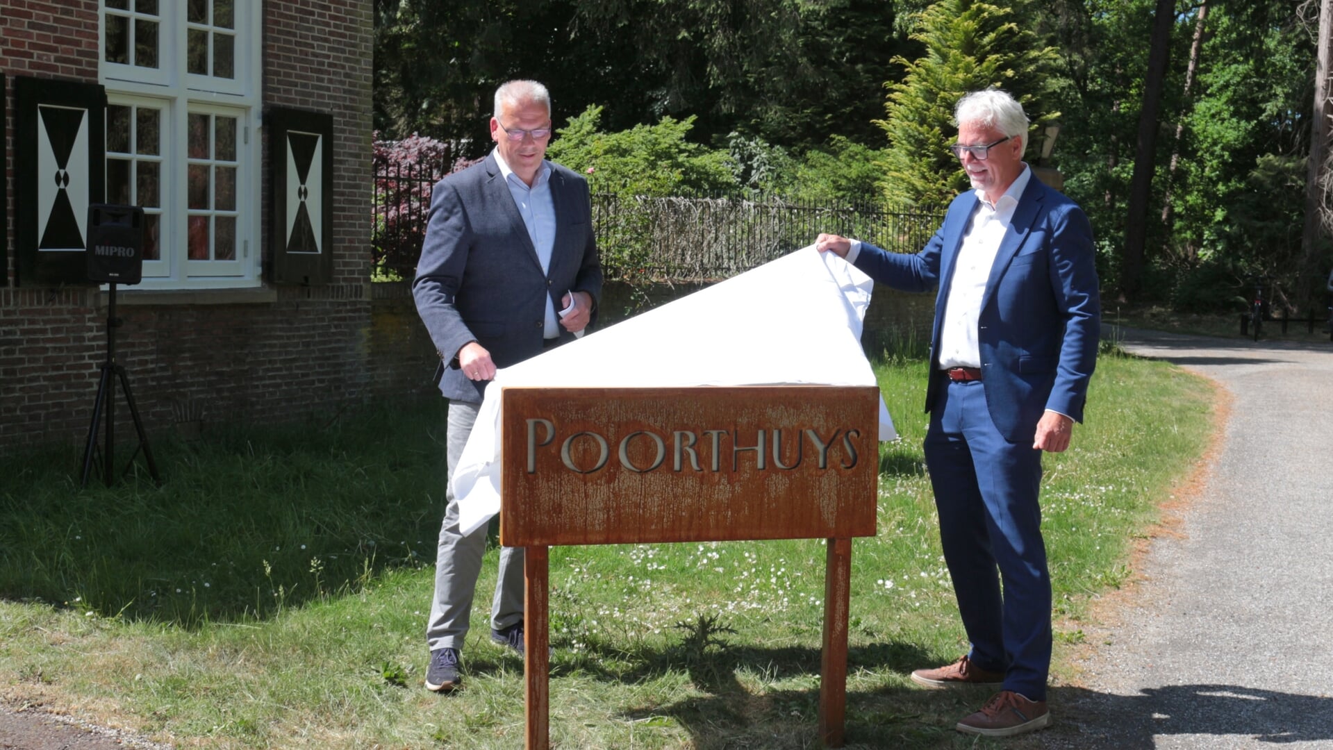 Wethouder opent Poorthuys, voor het afhalen van asbussen