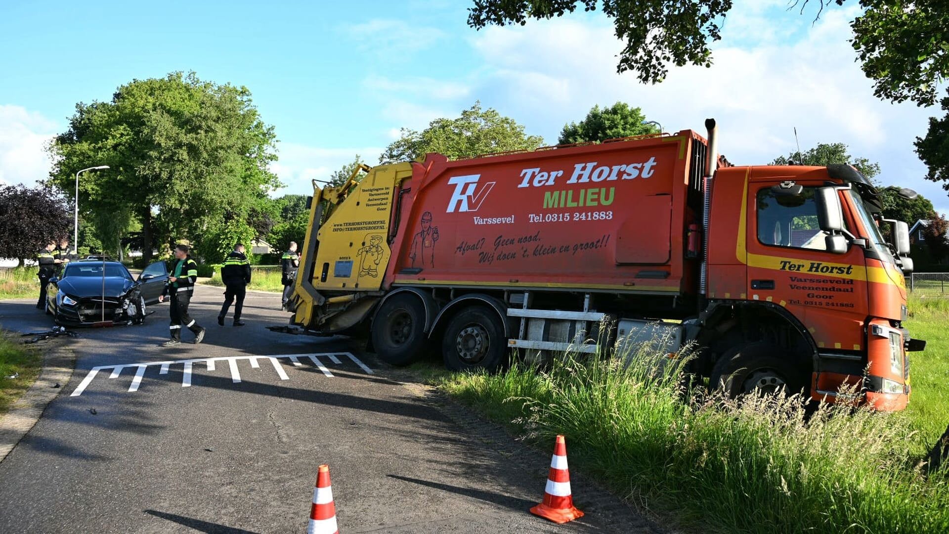 Vuilniswagen belandt in sloot na aanrijding op kruising in Kootwijkerbroek
