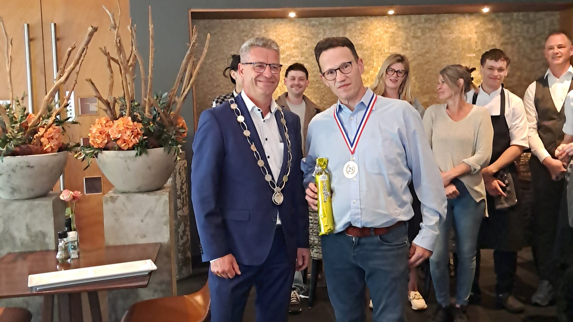 Burgemeester Heijkoop feliciteert Harm Rozendaal die al 25 jaar bij Kampagne in Hardinxveld-Giessend