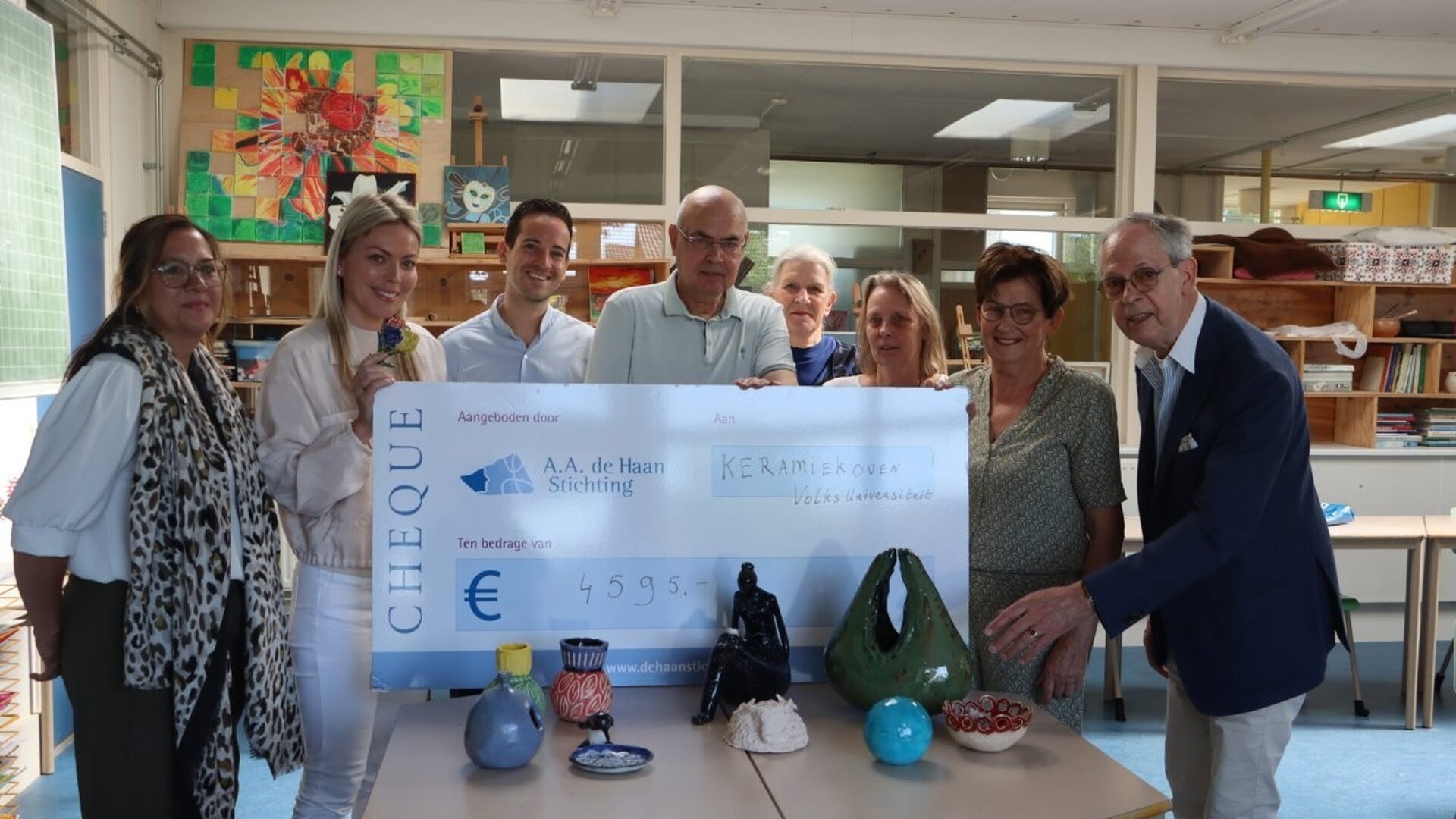 Cheque A.A. de Haan Stichting voor keramiekoven bij Volksuniversiteit Papendrecht