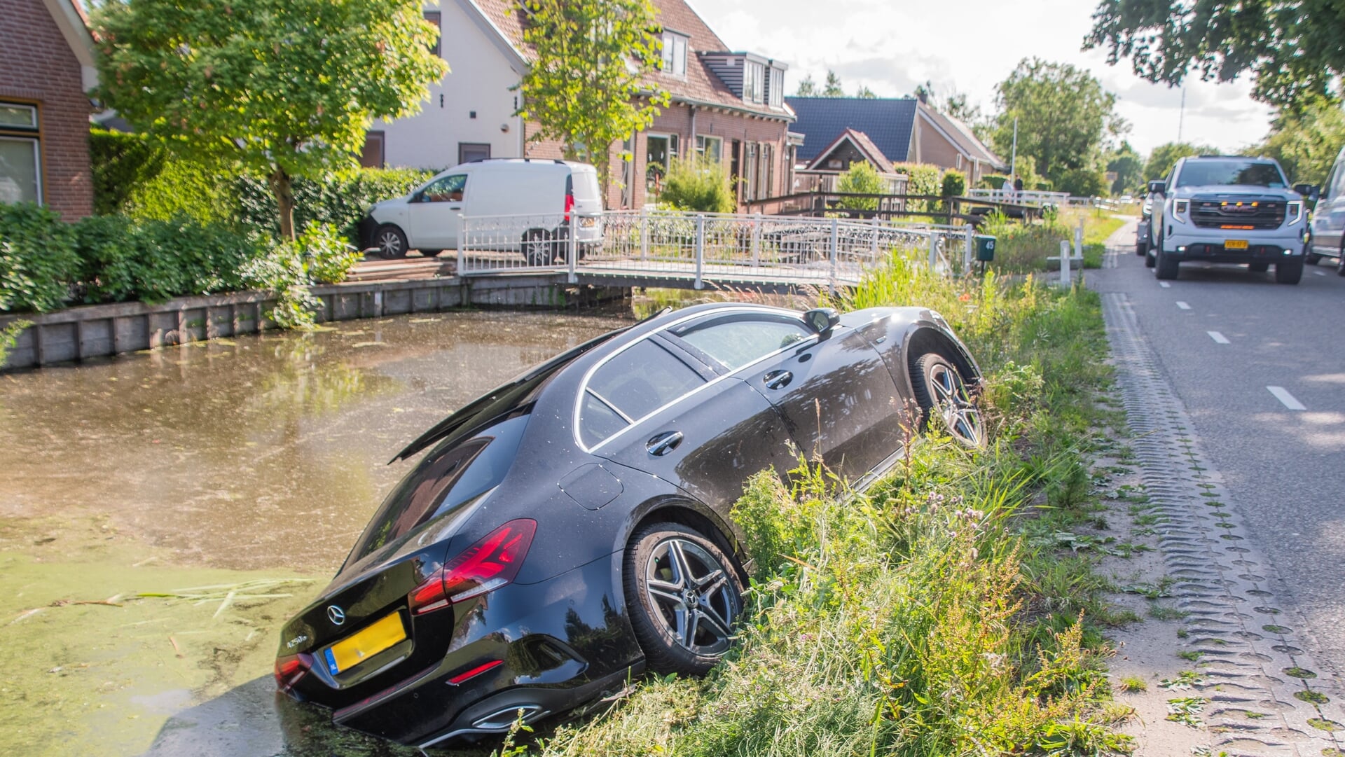 Auto balanceert op waterkant op Lopikerweg Oost in Lopik