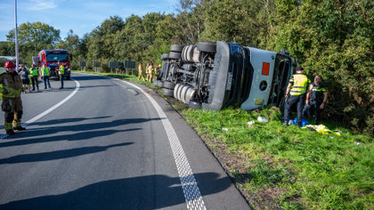 Vrachtwagen kantelt en belandt op zijkant in de berm langs A58